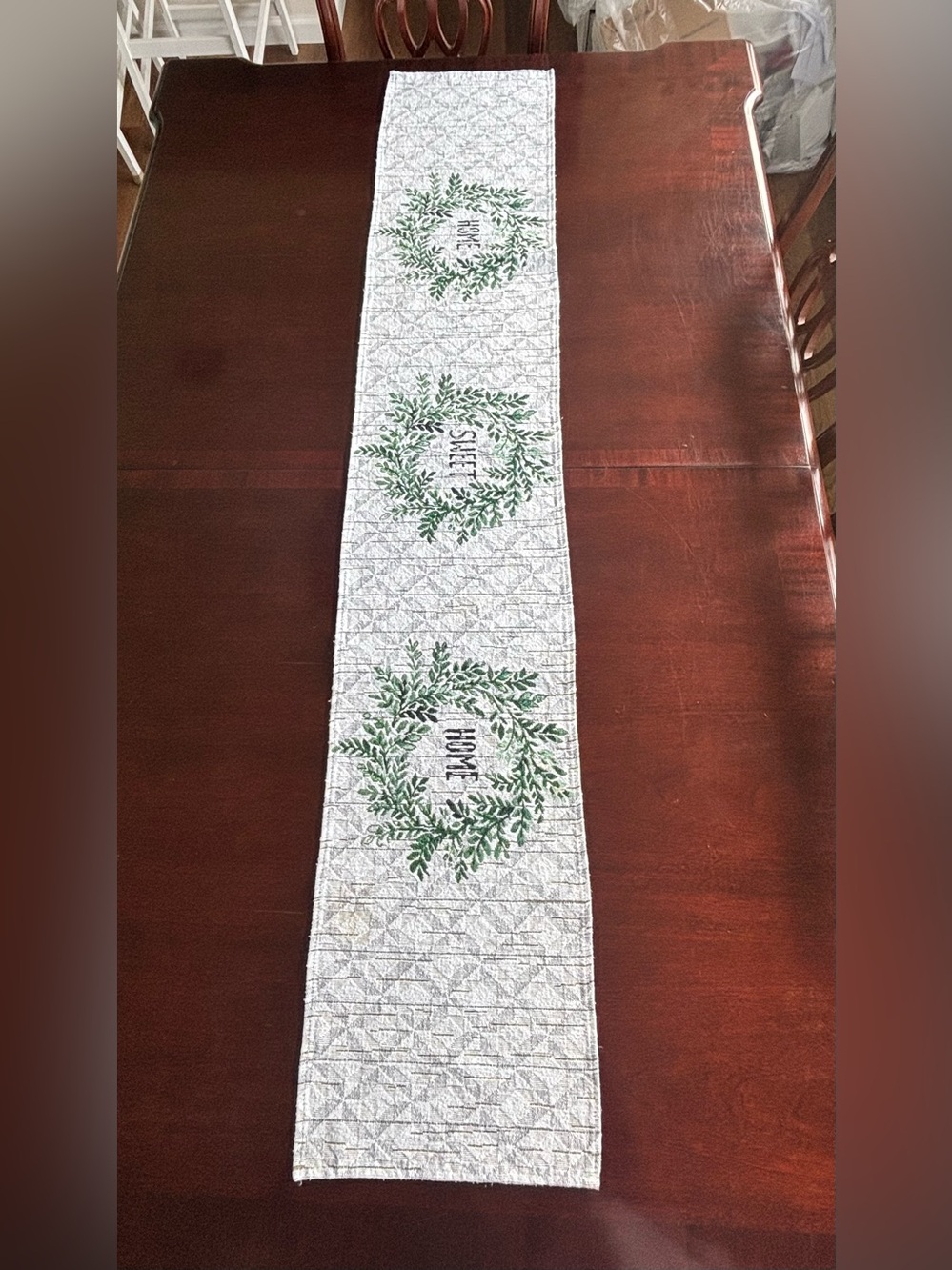 Festive White Table Runner with Green Wreath Motifs “Home Sweet Home”.